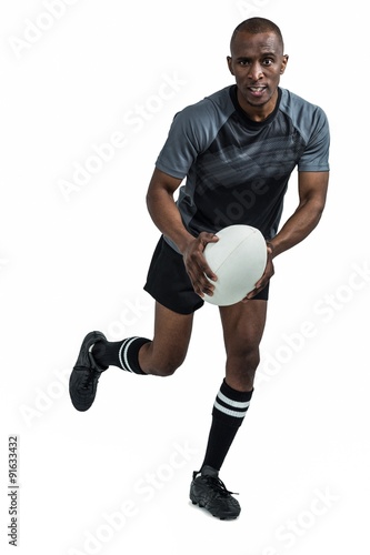 Portrait of determined sportsman running with rugby ball