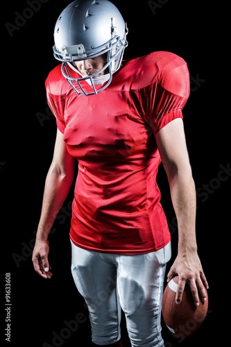 American football player looking down while standing