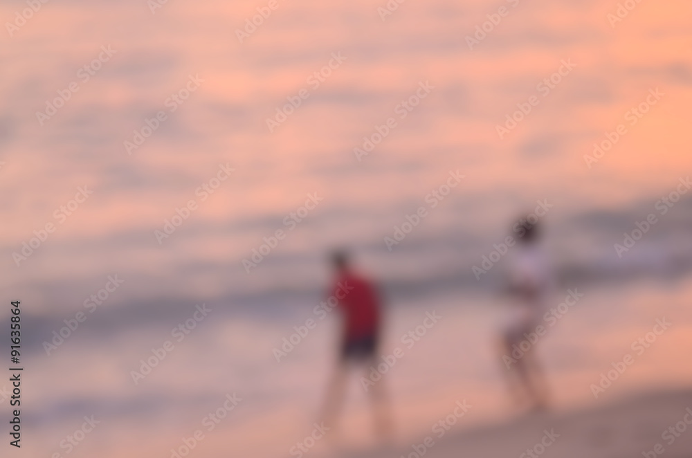 Fototapeta premium Blur children playing on tropical sunset beach abstract background.