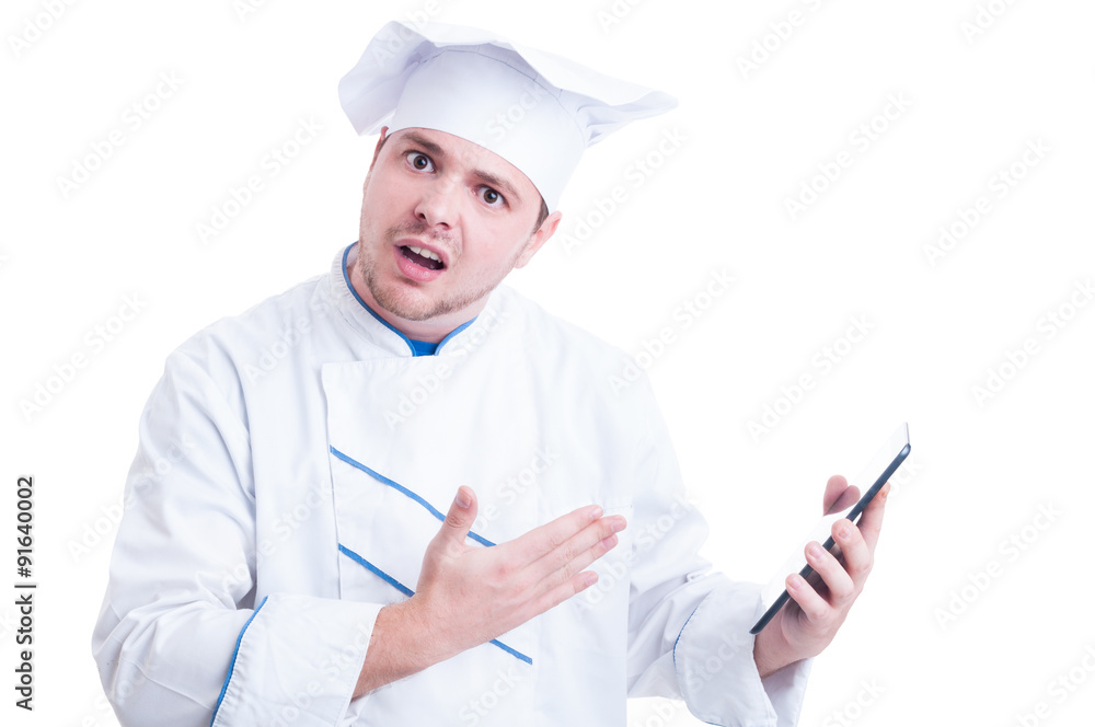 Shocked and outraged chef or cook holding a tablet Shocked and outraged chef or cook holding a tablet