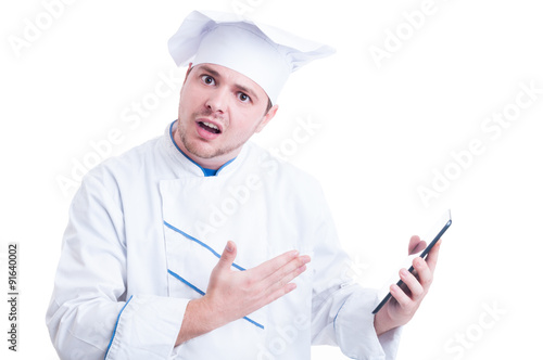 Shocked and outraged chef or cook holding a tablet