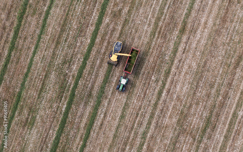 aerial view of harvest field with tractor and combine