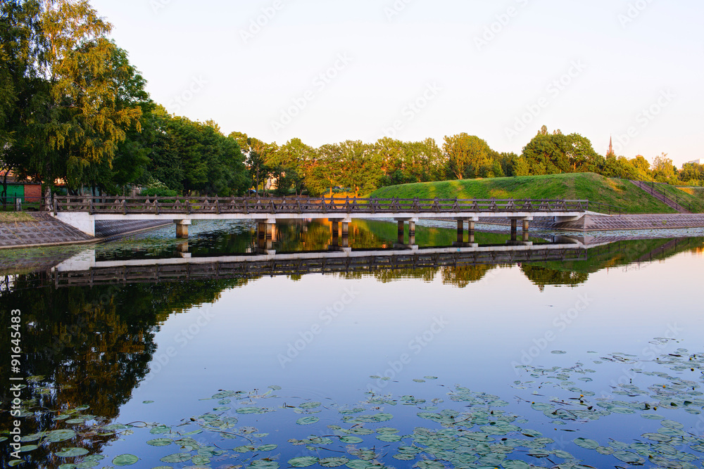 Fototapeta premium Vintage bridge over the pond. Sunset time. Klaipeda, Lithuania.