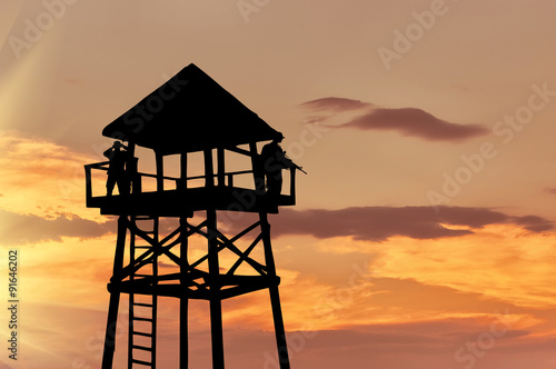Silhouette of a watchtower with soldiers photo