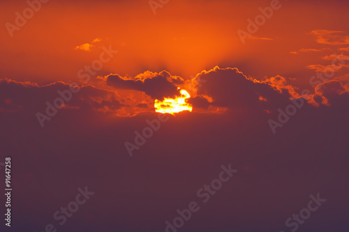 closeup of sun behind clouds at sunset