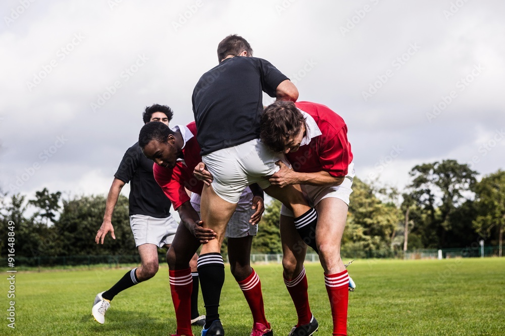 Fototapeta premium Rugby players tackling during game
