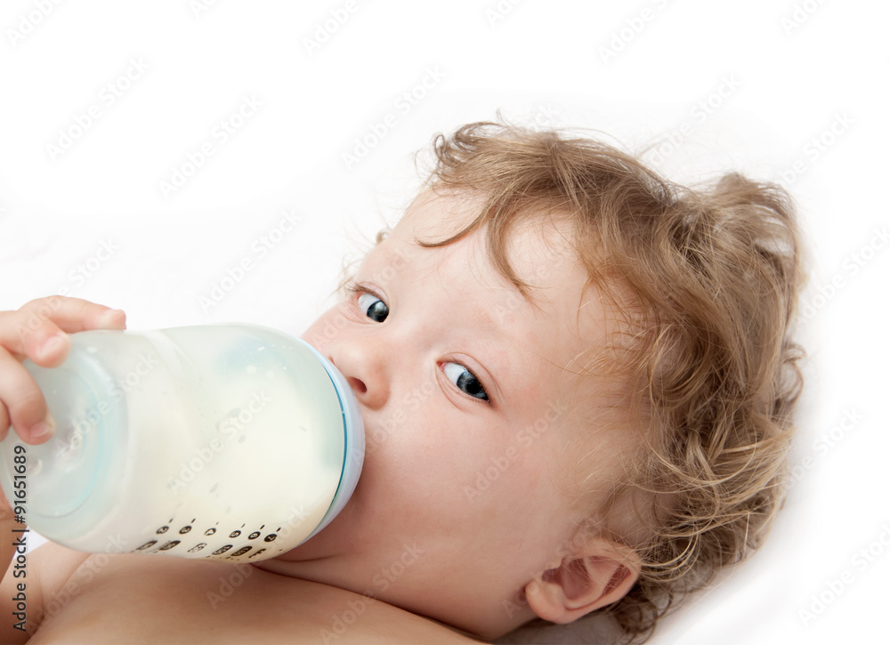 little curly-headed baby sucks a bottle of milk little curly-headed baby sucks a bottle of milk