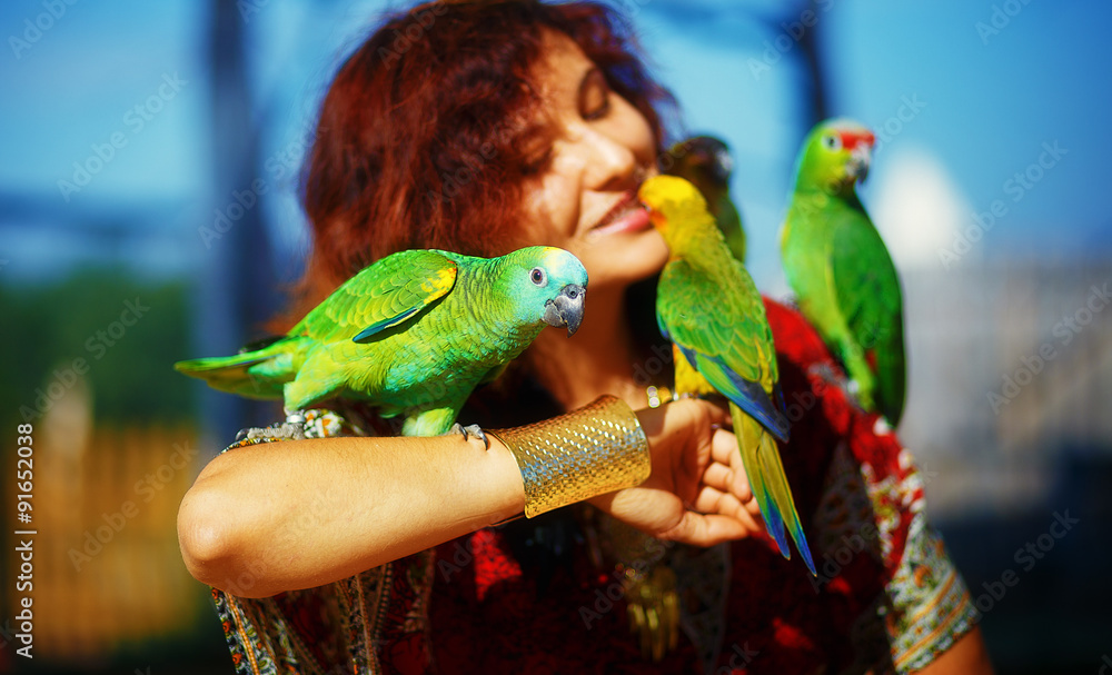 Obraz premium woman in ornamental dress and gold jewelry with colorful parrots