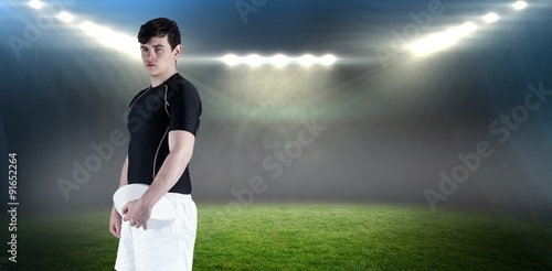 Composite image of rugby player holding a rugby ball © vectorfusionart