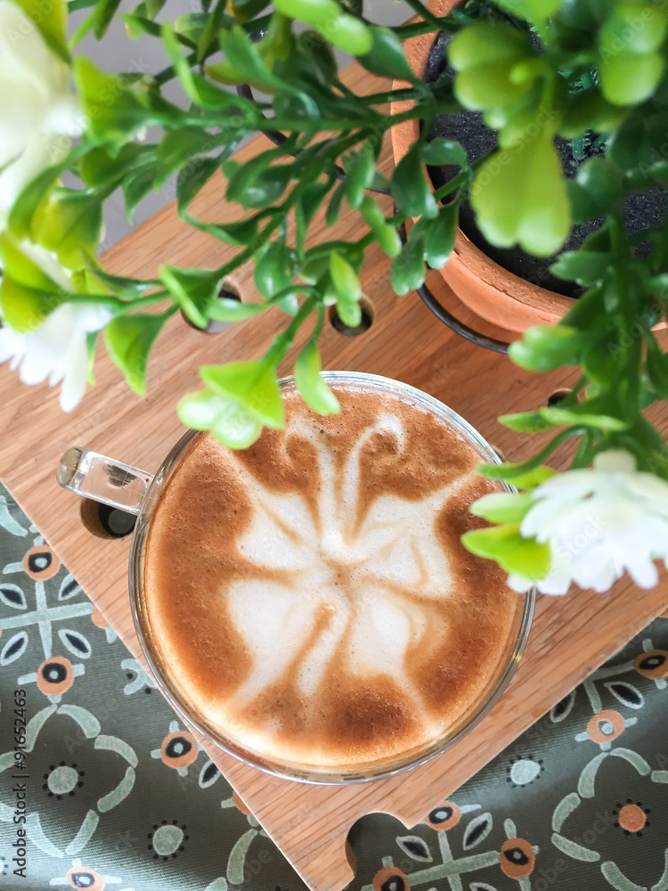 Butterfly shape of latte art coffee on wooden background Butterfly shape of latte art coffee on wooden background