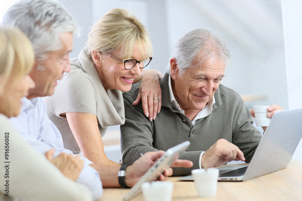 Group of retired senior people using laptop and tablet - obrazy, fototapety, plakaty 