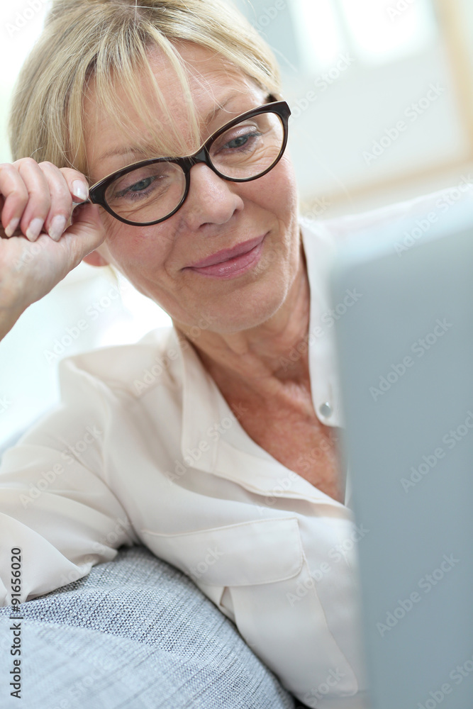 Senior woman with eyeglasses connected on digital tablet Senior woman with eyeglasses connected on digital tablet