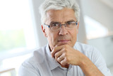 Portrait of senior man with grey hair wearing eyeglasses