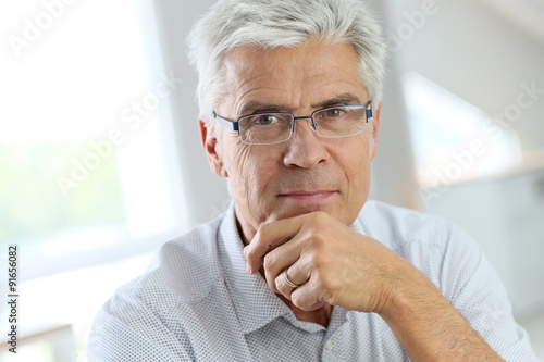 Portrait of senior man with grey hair wearing eyeglasses
