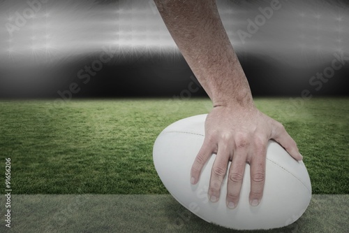 Composite image of close-up of sports player holding ball