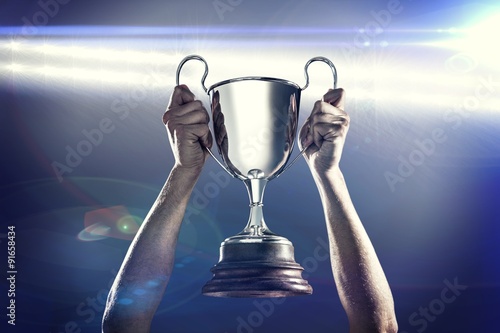 Foto Composite image of successful rugby player holding trophy