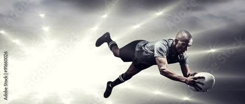 Composite image of sportsman jumping for catching rugby ball © vectorfusionart