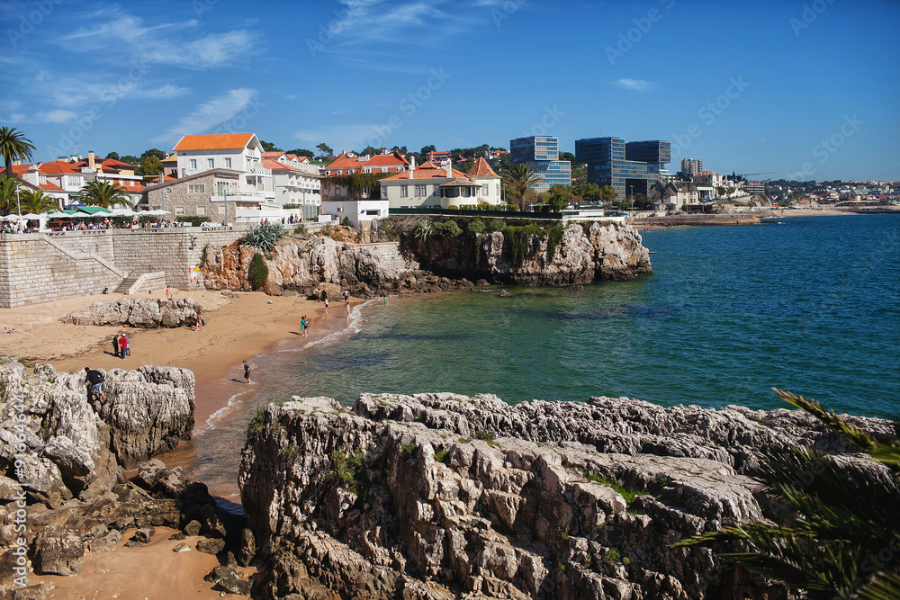 rocky beach with people and villas and houses in the background