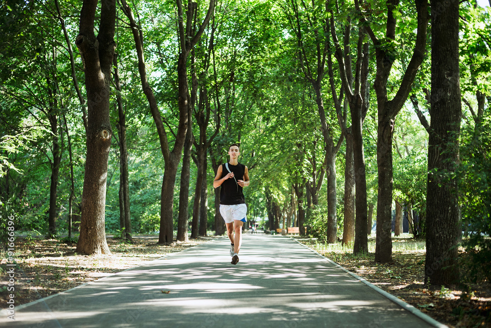 young caucasian male running in park. Teenager jogging in park young caucasian male running in park. Teenager jogging in park