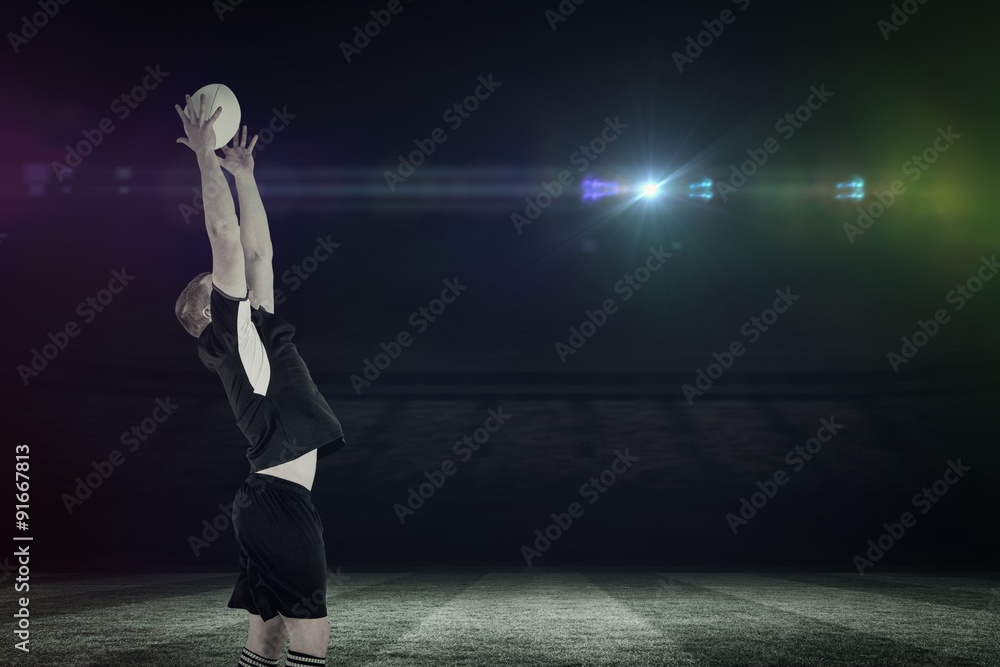 Fototapeta premium Composite image of rugby player catching a rugby ball