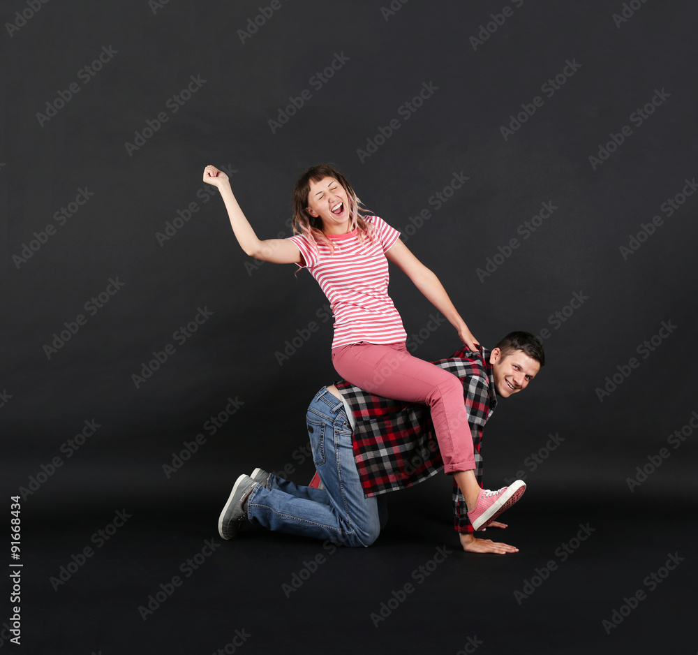 Emotional young couple on black background