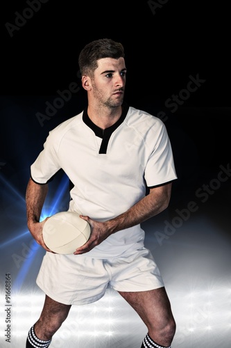 Composite image of rugby player defending with the ball