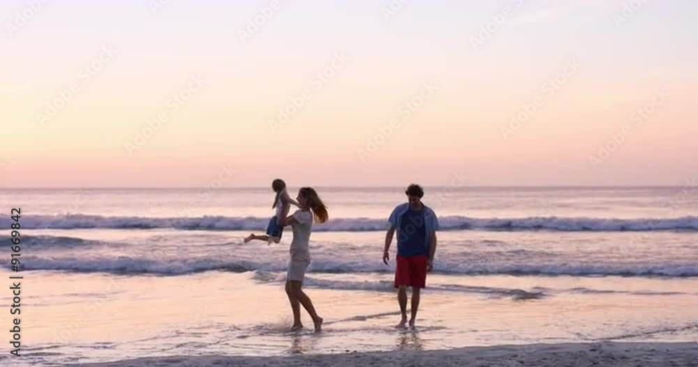Mother swinging little girl around Happy family on the beach holding hands at sunset on vacation Mother swinging little girl around Happy family on the beach holding hands at sunset on vacation