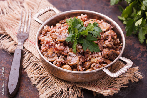Rice with mushrooms  and fresh parsley vintage saucepan.selective focus