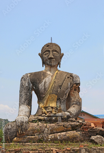 he ruin of Wat Phia Wat near Phonsavan in Laos. The area was subject to bombing during the Vietnam War and this buddha statue and some walls are all that remain of this temple.   photo