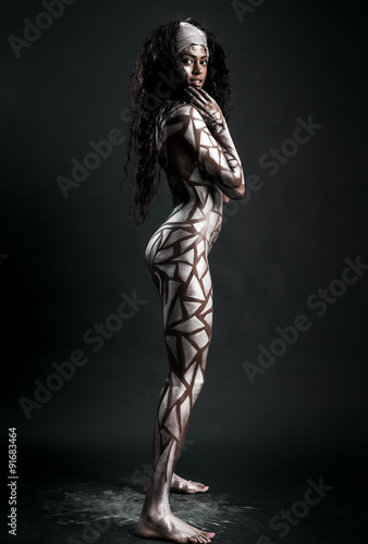 Sexy african model posing with body painted with white polygons