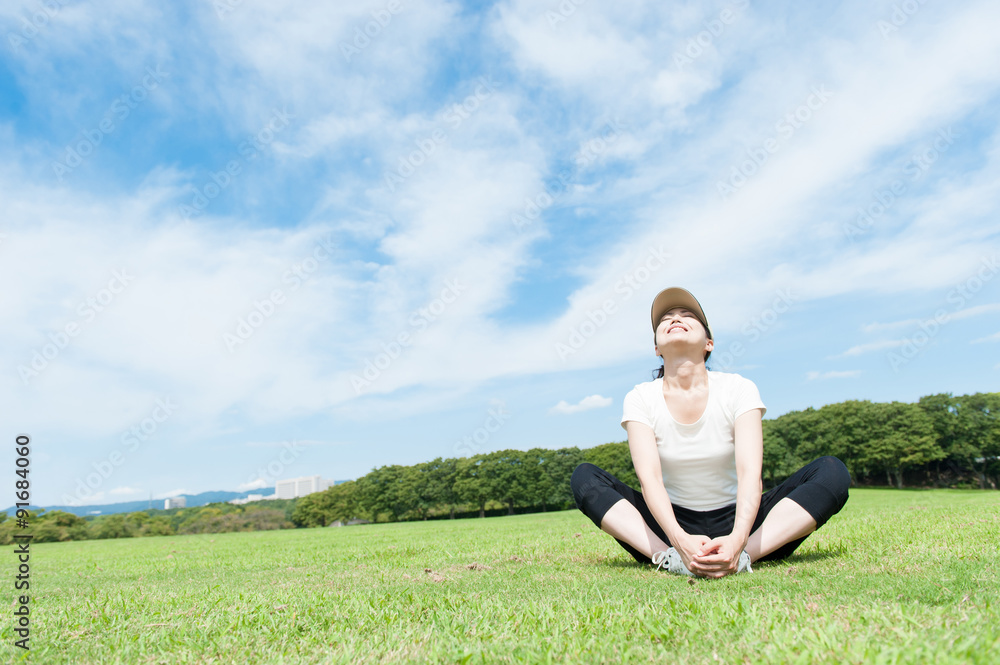 広い公園,ストレッチをする女性