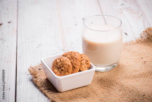 milk in glass with cookies on stack