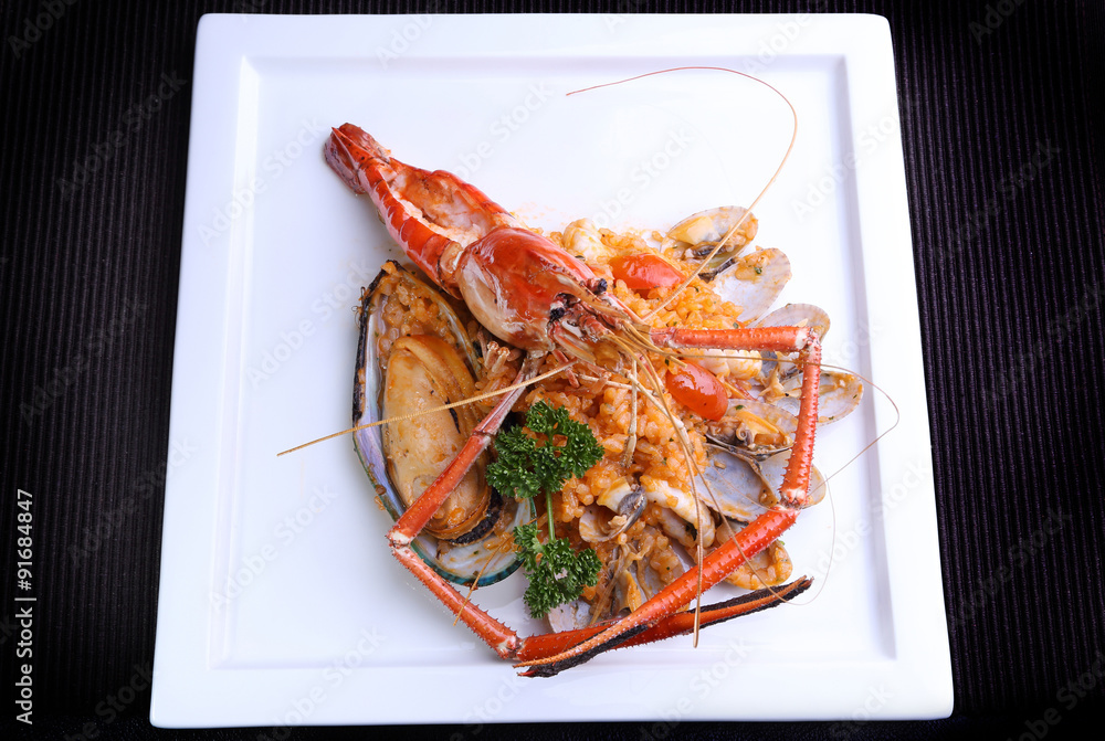 Seafood Risotto on white plate, popular international food from rice Seafood Risotto on white plate, popular international food from rice