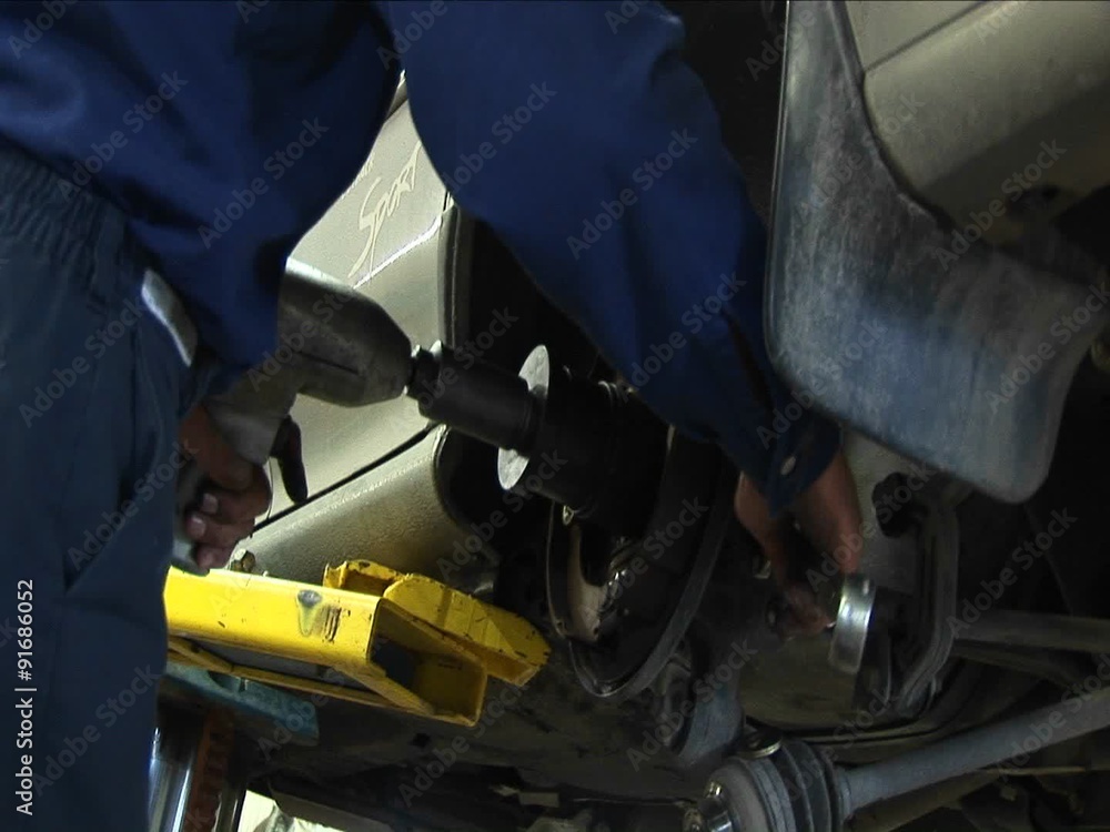 A mechanic works on a wheel repair with a variety of tools. A mechanic works on a wheel repair with a variety of tools.