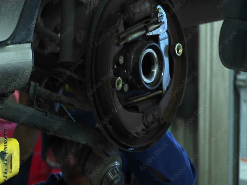 Close-up of a mechanic working on a wheel-mount repair. Close-up of a mechanic working on a wheel-mount repair.