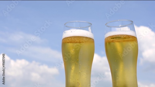 青空をバックに2本のグラスのビール