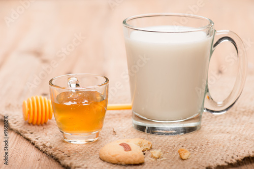 glass of milk with honey and cookie