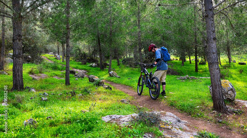 Bicyclists walking in a green forest
