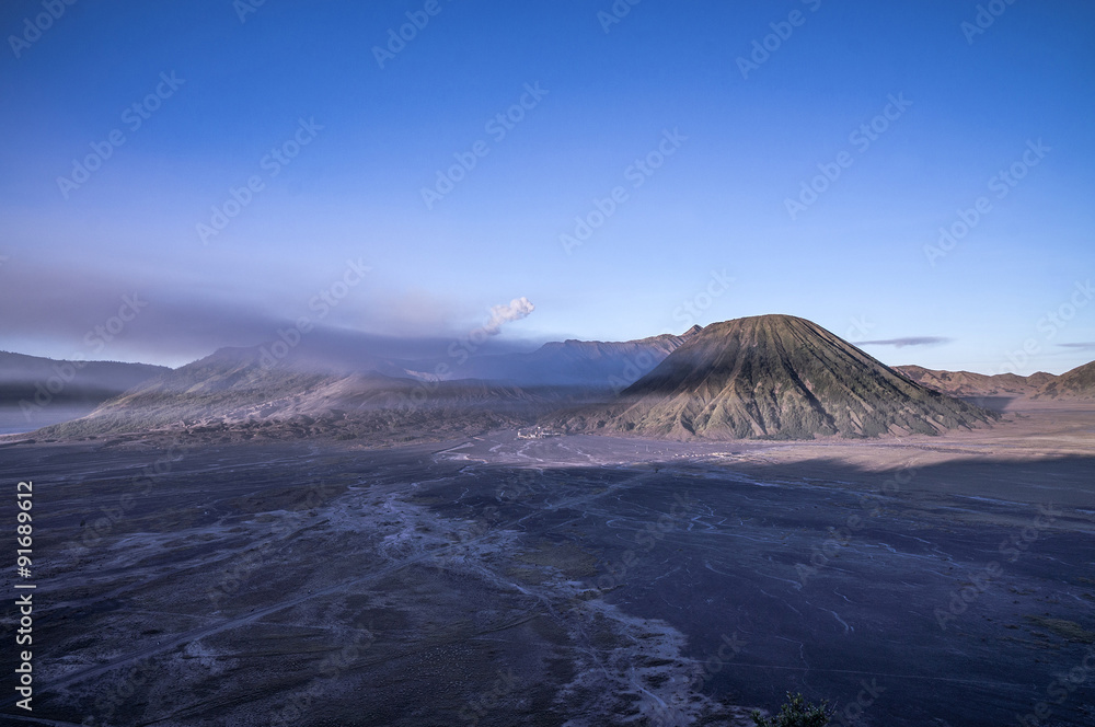 Mt Bromo during sunrise with blue sky and foggy moment