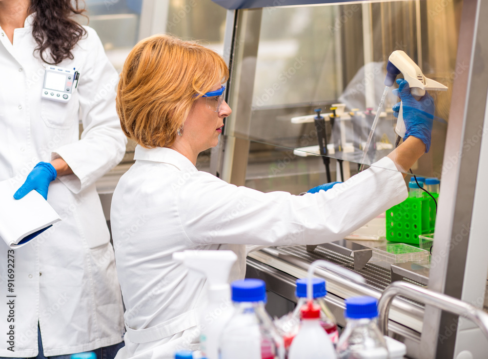 Photo of real female scientists researching in laboratory. Photo of real female scientists researching in laboratory.