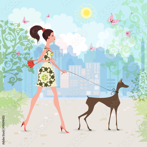 Lovely girl and her dog are walking in the city.