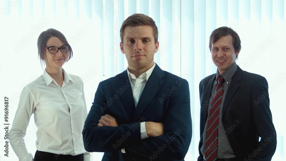 Team of three successful business people looking into the camera Team of three successful business people looking into the camera