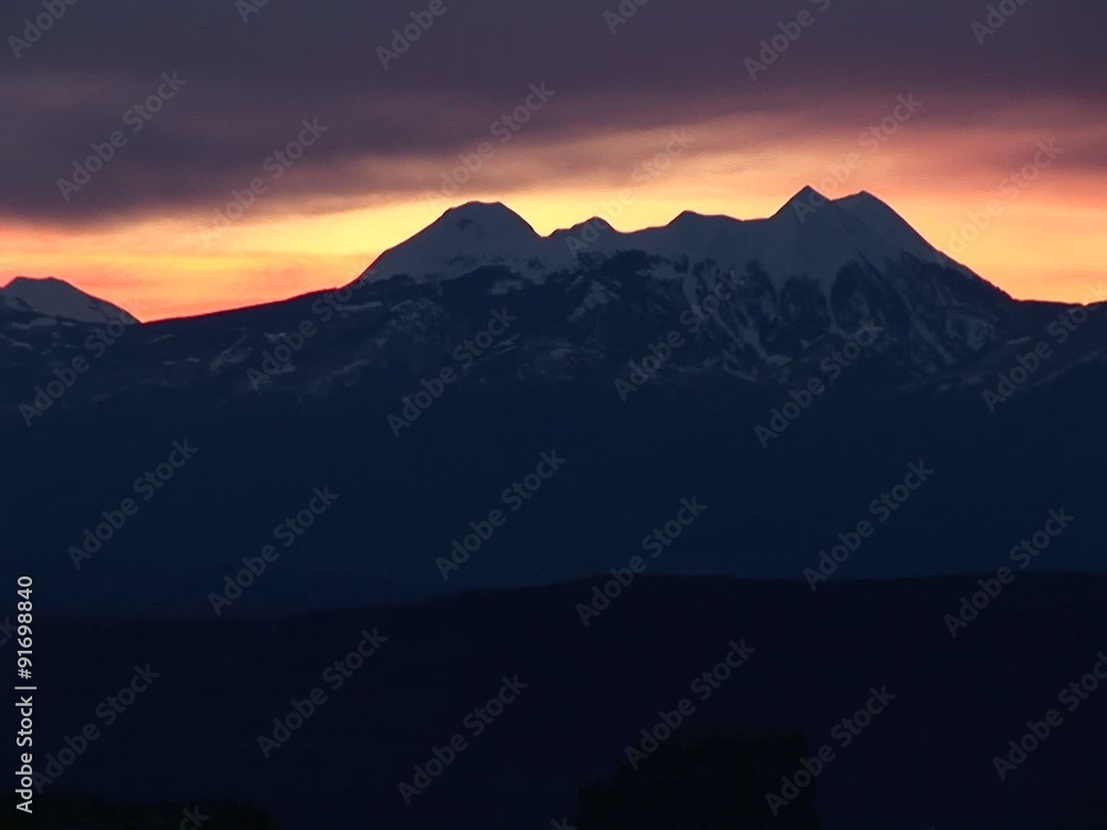 Long-shot of the La Sal Mountains silhouetted against a golden sky. Long-shot of the La Sal Mountains silhouetted against a golden sky.