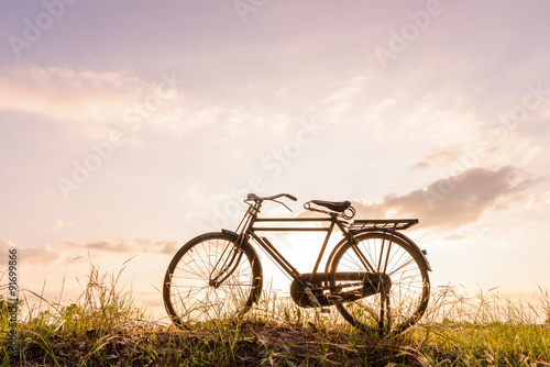 beautiful landscape image with Bicycle at sunset