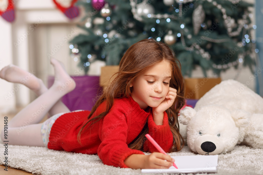 Nice girl playing near Christmas tree Nice girl playing near Christmas tree