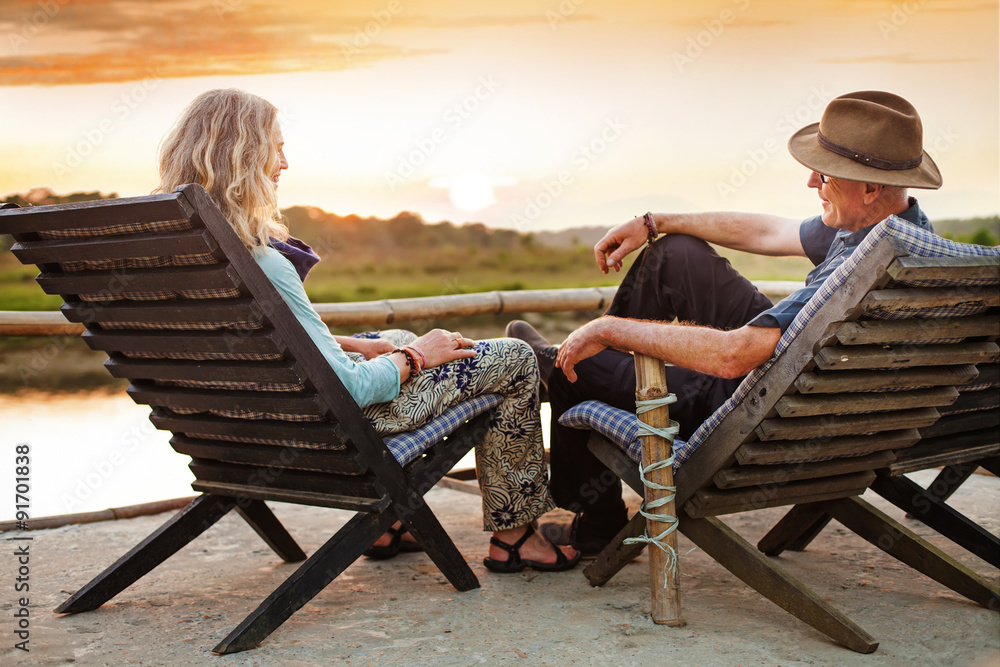 mature retired couple from back sitting on chairs