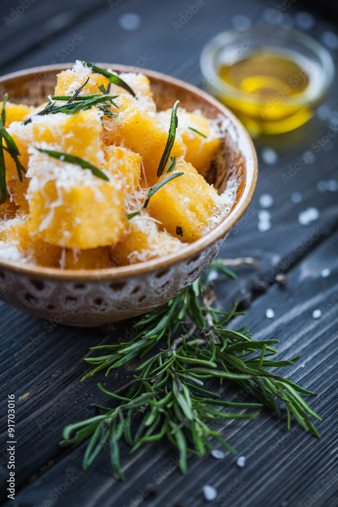 Crunchy croutons in bowl with rosemary