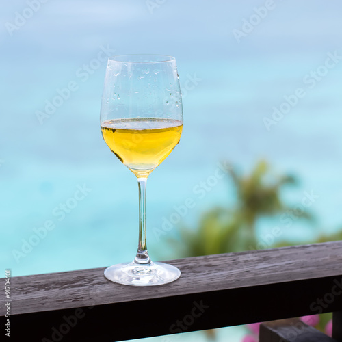 Glass of white wine on balcony rail