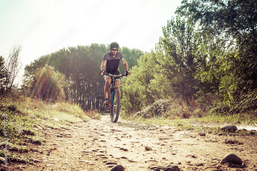 Man riding on a dirty road on a mountain bike
