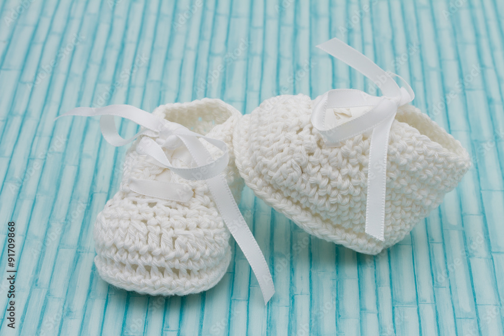 White Baby Booties on wood background White Baby Booties on wood background